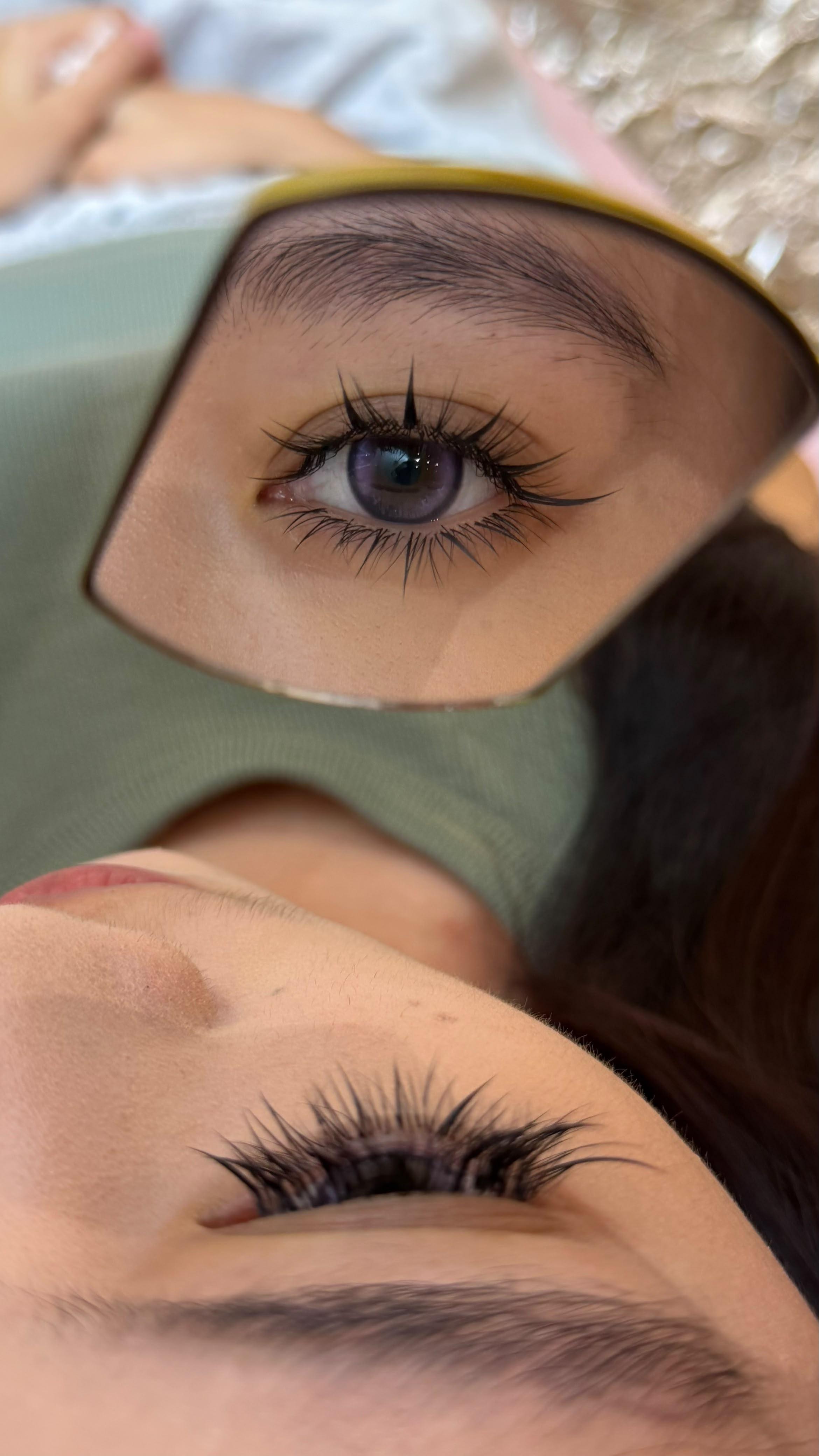 Anime-inspired eyelash extensions reflected in a mirror