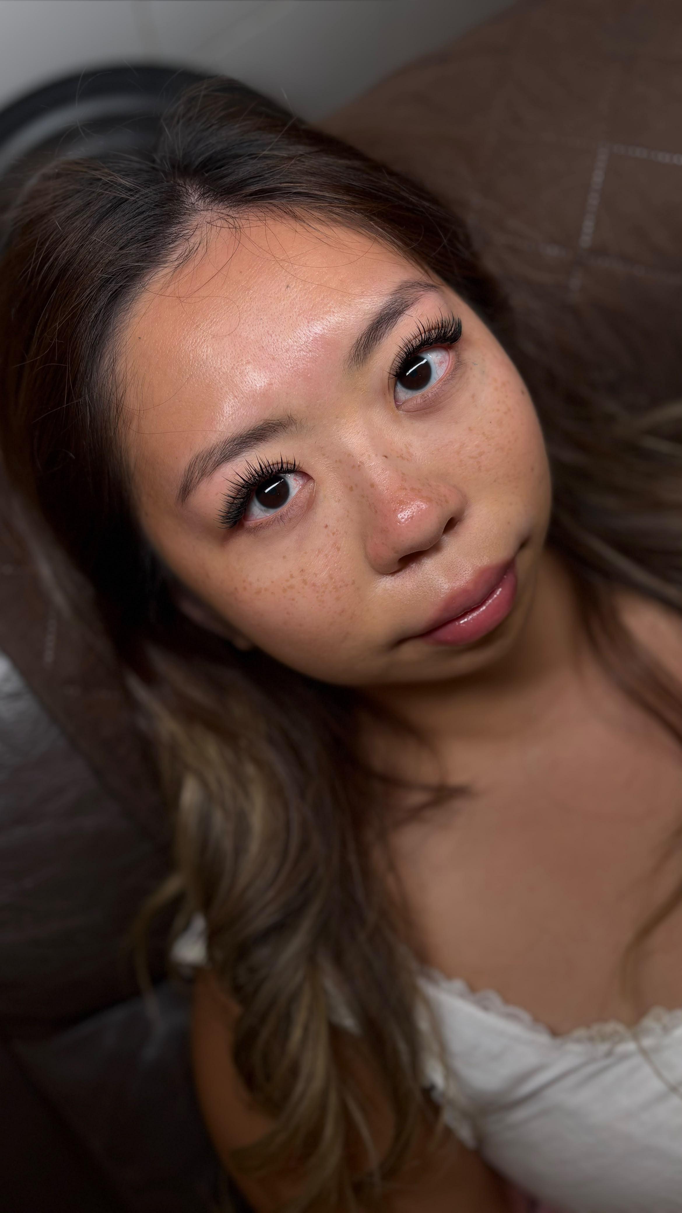 Soft wispy eyelash extensions on a freckled client